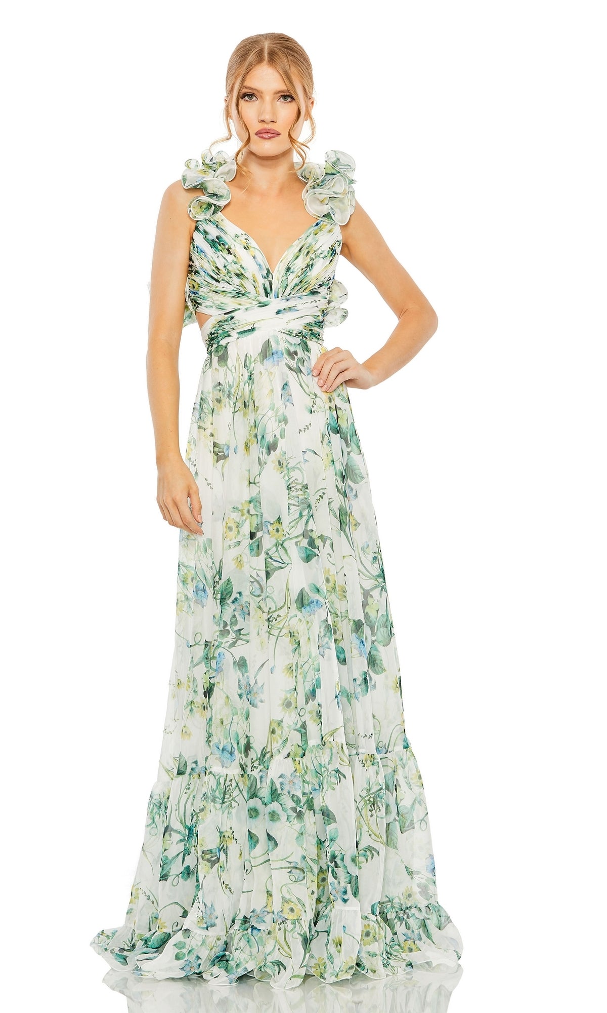 A woman models the Long Formal Dress 68521 by Mac Duggal, a sleeveless, floor-length A-line gown featuring green and blue floral patterns with ruffled shoulders.